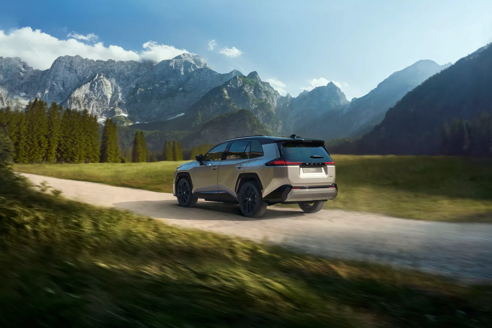 Foto: neuer RAV4 in grau seitlich von hinten auf der Straße im Gebirge Auto Ebner